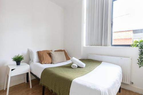 a small bedroom with a bed and a window at Shoreditch Apartments by DC London Rooms in London