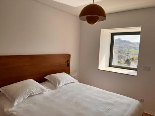 a bedroom with a white bed and a window at Casa Sao Bento in Arcos de Valdevez