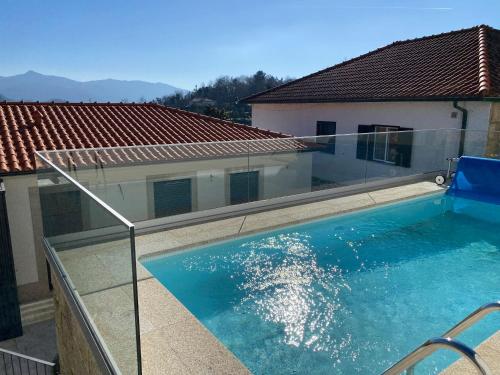 a swimming pool on a balcony with a house at Casa Sao Bento in Arcos de Valdevez