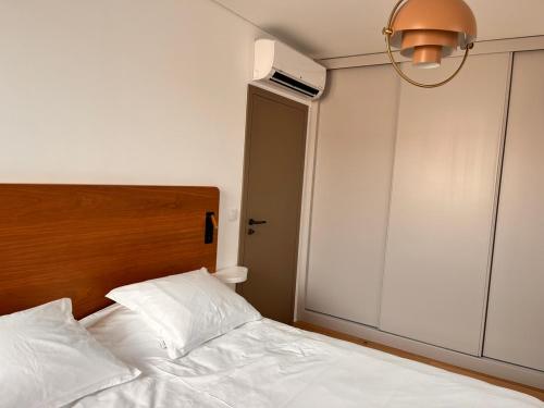 a bedroom with a white bed with a wooden headboard at Casa Sao Bento in Arcos de Valdevez