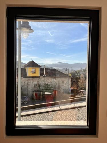a window with a view of a building at Casa Sao Bento in Arcos de Valdevez