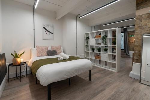 a bedroom with a bed with a teddy bear on it at Shoreditch Apartments by DC London Rooms in London