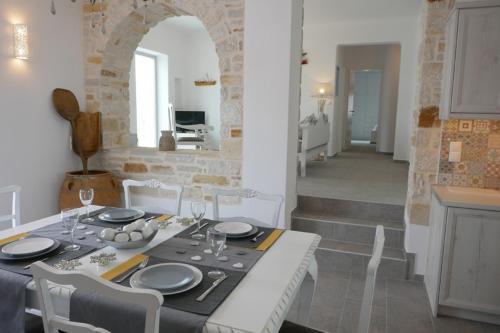 a dining room with a table and chairs and a kitchen at Villa Logaras in Márpissa
