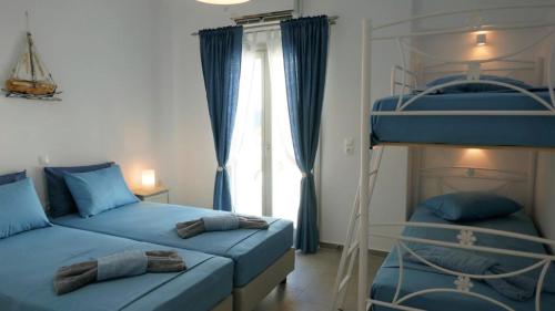a bedroom with two bunk beds and a window at Villa Logaras in Márpissa