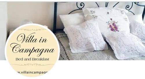 een bed met witte kussens en een bordje met wild in campagnebed bij Villa in campagna in Calvisano