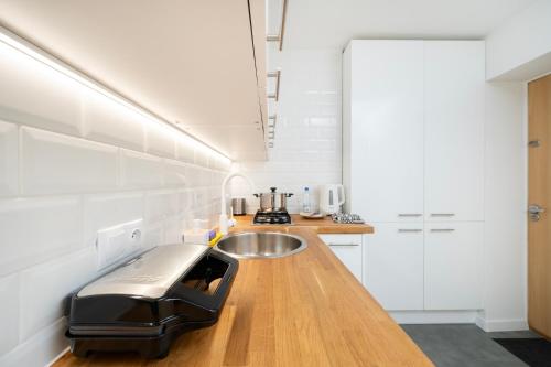 eine Küche mit einer Spüle und einer Theke mit einem Toaster in der Unterkunft Atlas Arena Comfort Studio in Łódź