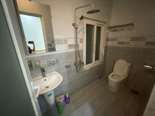 uma casa de banho com um lavatório, um WC e um chuveiro em MIAN HOUSE em Da Lat