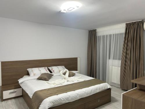 a bedroom with a large bed with white sheets at Pensiunea La Cazemata Bucov in Satu Bucovei