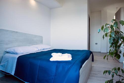 a bed with blue sheets and white towels on it at Albamarina in SantʼAntìoco