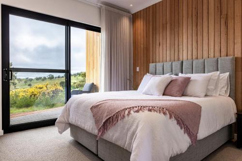 a bedroom with a large bed with a large window at Benbullen Retreat in Angaston