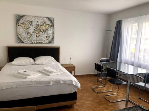 1 dormitorio con cama y mesa de cristal en Bright and quiet studio in the city center (Sky1) en Zúrich