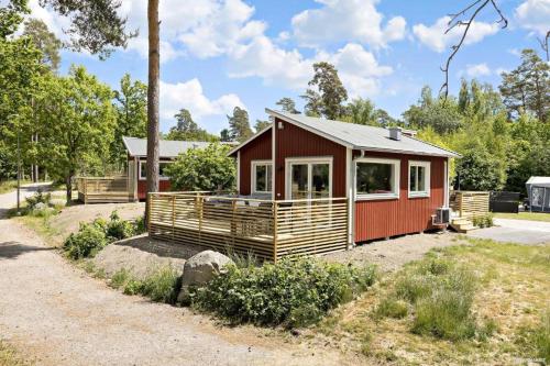une petite maison rouge avec une terrasse couverte dans l'établissement First Camp Stensö-Kalmar, à Kalmar
