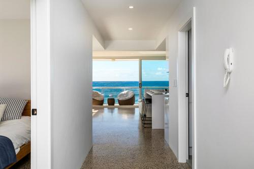 a bedroom with a bed and a view of the ocean at Yulunga - Direct Beachfront in Narrabeen