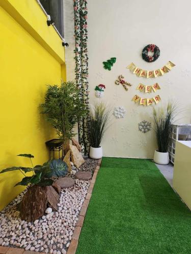 a garden with green grass and plants on the side of a building at 9 House&homeStay in Hat Yai
