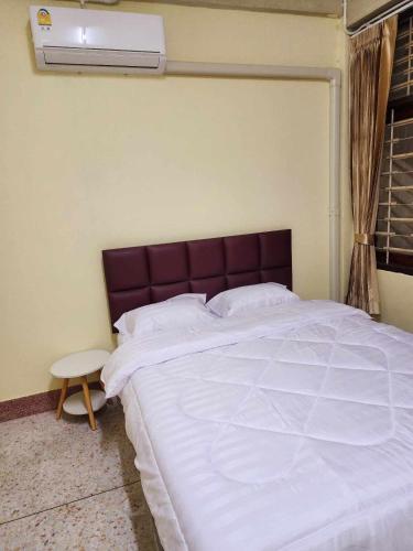 um quarto com uma cama grande e uma cabeceira castanha em 9 House&homeStay em Hat Yai