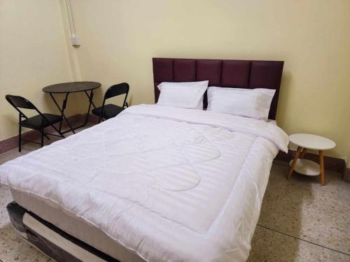 uma cama grande num quarto com duas mesas e cadeiras em 9 House&homeStay em Hat Yai