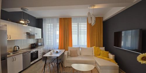 a living room with a white couch and a kitchen at Apartament Pod 12 in Bielsko-Biała