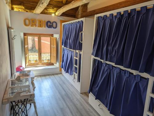 Habitación con cortinas azules y ventana en Albergue Casa de los Hidalgos - Sólo para Peregrinos, en Hospital de Órbigo