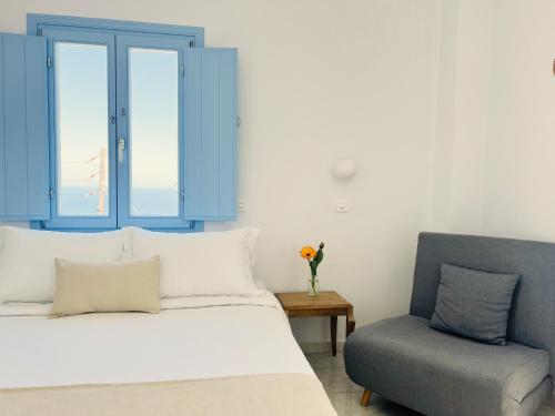 a bedroom with a bed and a blue cabinet and a chair at Villa Fotini in Firostefani