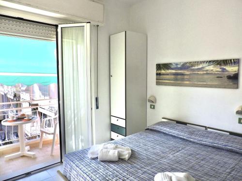 een slaapkamer met een bed en een balkon bij Hotel Villa Chiara in Finale Ligure