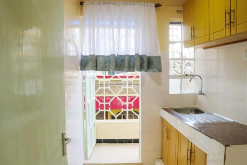 eine Küche mit einer Tür, die zu einem Fenster führt in der Unterkunft Dayo Suites & Hotel in Nairobi