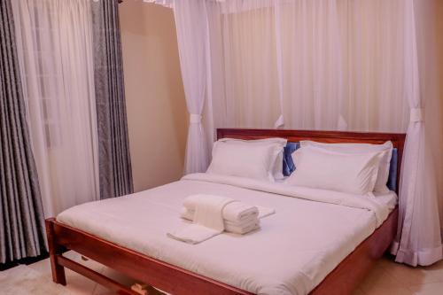a bedroom with a bed with two towels on it at Dayo Suites & Hotel in Nairobi