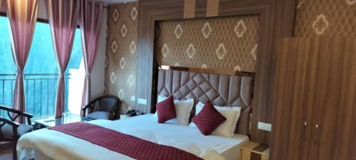 a bedroom with a large bed with red pillows at Summer Hill Resort in Chail