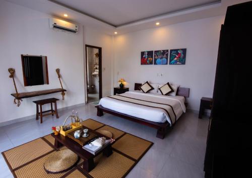 Schlafzimmer mit einem Kingsize-Bett und einem Klavier in der Unterkunft Hoi An Fairy Garden Villa in Hoi An
