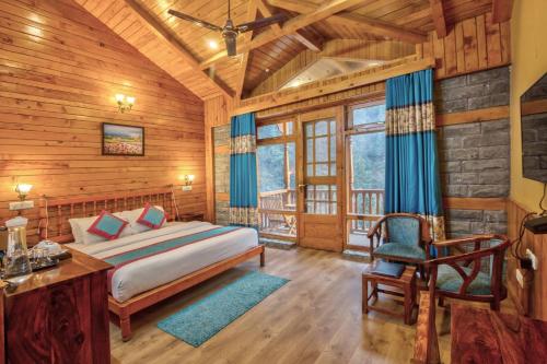 a bedroom with a bed and a desk and a chair at The Blue Stream Cottage in Jibhi