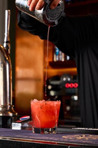 a person is pouring a drink into a cocktail at The Burlington in Worthing
