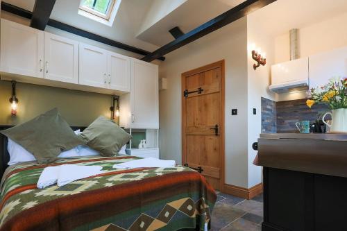 a bedroom with a bed and a kitchen with a window at Cosy countryside retreat, Weiser in Buckinghamshire