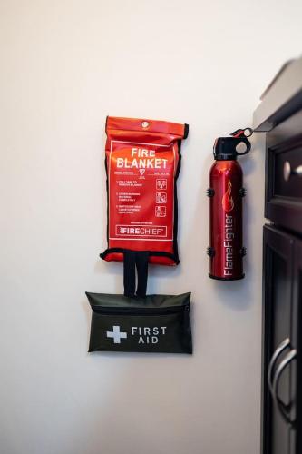 a first aid bag and a fire extinguisher on a wall at Cosy countryside retreat, Weiser in Buckinghamshire