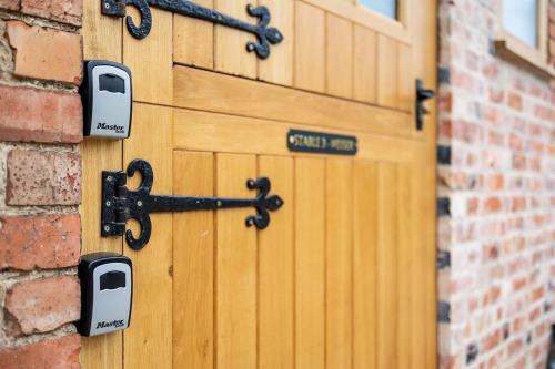 a wooden door with locks on a brick wall at Cosy countryside retreat, Weiser in Buckinghamshire