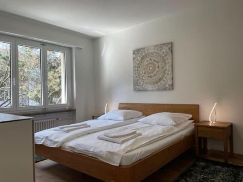 - une chambre avec un lit doté de draps blancs et 2 fenêtres dans l'établissement Beautiful, quite and very central 2 bedroom flat (Sky6), à Zurich