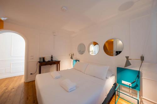 a bedroom with a white bed and two mirrors at Giardini Penelope Resort e Spa in Ciampino