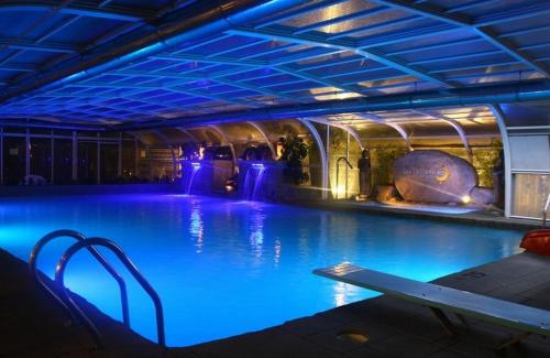 - une piscine avec éclairage bleu dans un bâtiment dans l'établissement Spa Natura Resort, à Peñíscola
