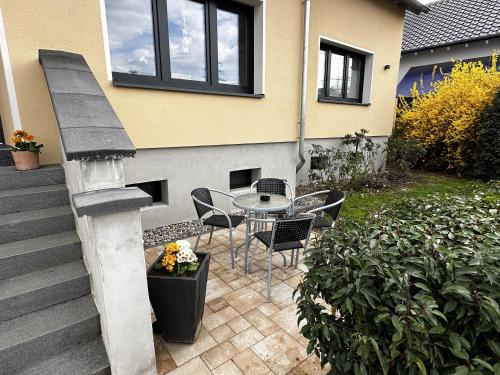 a patio with a table and chairs next to a house at Haus Alt - Ferienwohnung in Illingen