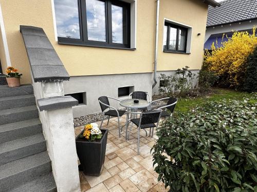 un patio con mesa y sillas junto a una casa en Haus Alt - Ferienwohnung, en Illingen