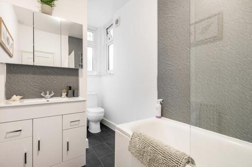 een badkamer met een bad, een toilet en een wastafel bij Beautiful 1-Bed Apartment with Garden in London in Londen