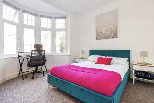 a bedroom with a bed and a desk and windows at Beautiful 1-Bed Apartment with Garden in London in London