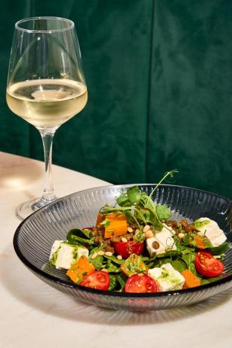 a plate of salad next to a glass of wine at The Burlington in Worthing