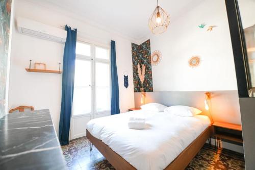 une chambre avec un grand lit avec des rideaux bleus dans l'établissement Le Flower, Beau T3, Climatisé, Centre Ville, à Montpellier
