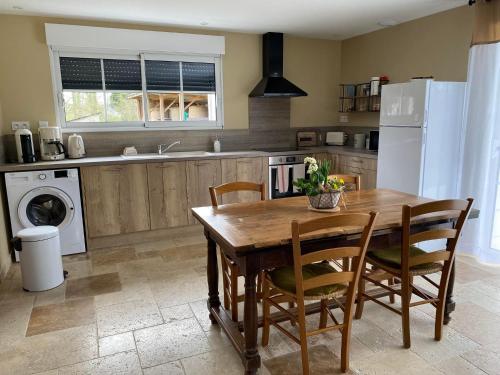 Thenay的住宿－Gîte La Cabuche proche du zoo de Beauval，厨房配有带椅子的木桌和白色冰箱。