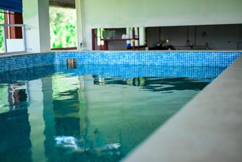een zwembad met blauwe tegels op de vloer bij HOTEL ALL SEASON in Havelock Island