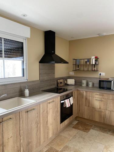 a kitchen with a sink and a stove top oven at Gîte La Cabuche proche du zoo de Beauval in Thenay