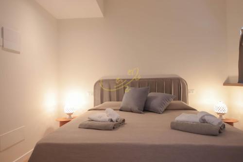 a bedroom with a large bed with two pillows at Alberobbè luxury rooms in Alberobello