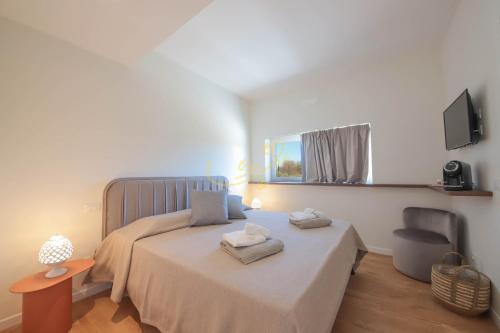 a bedroom with a bed with two towels on it at Alberobbè luxury rooms in Alberobello