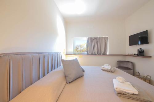 a room with a bed with two towels on it at Alberobbè luxury rooms in Alberobello