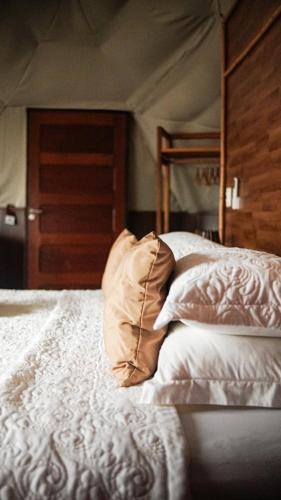 a bed with a pillow sitting on top of it at Casa do Imperador in Fernando de Noronha