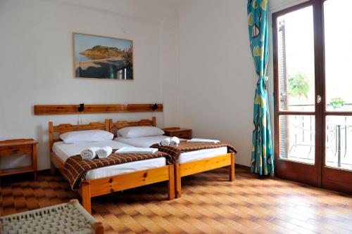 a bedroom with a bed and a large window at PensionMargaritaKotroniSkiathos in Skiathos Town